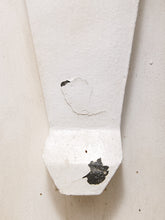 Load image into Gallery viewer, A close-up of a white painted wooden wall bracket or shelf support with peeling paint and visible dark wood showing through the chipped areas.