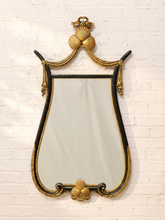 Load image into Gallery viewer, Vintage black and gold Hollywood Regency wall mirror with ornate gilt shell crest, ribbon details, bead trim, and curved decorative frame.