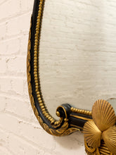 Load image into Gallery viewer, Close-up of an ornate gold and black decorative mirror frame mounted against a white painted brick wall.