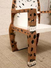 Load image into Gallery viewer, A rustic wooden chair with a cowhide pattern, featuring a white-painted seat and backrest, set on a beige carpet against a white brick wall.