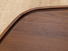 Load image into Gallery viewer, Close-up of a dark brown wooden tray with a smooth, rounded corner and visible wood grain texture.