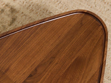 Load image into Gallery viewer, Close-up of a polished medium-brown wooden tray or table corner with a rounded edge, showing the wood grain and glossy finish against a beige textured background.