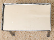 Load image into Gallery viewer, A rectangular silver metal tray with a decorative beaded border and two small feet, shown from above on a textured beige woven rug.