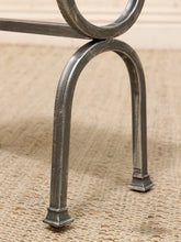 Load image into Gallery viewer, Close-up of a rustic metal furniture leg with a distressed silver finish, resting on a beige woven rug.