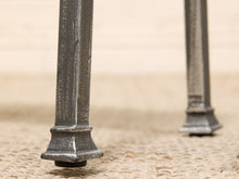 Load image into Gallery viewer, Close-up of the metal legs of a table on a textured beige rug, with a soft-focus background.