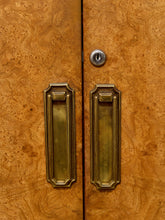 Load image into Gallery viewer, Close-up of a pair of doors with rich burl wood grain in warm golden-brown tones, featuring ornate brass pull handles and a matching keyhole.