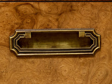 Load image into Gallery viewer, An ornate antique brass drawer pull with a rectangular glass window, mounted on a richly textured burl wood drawer front.