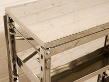 Load image into Gallery viewer, Close-up of a modern industrial table or shelf with a white marble-look top and a polished stainless steel frame, showing the corner joint and lower shelf.