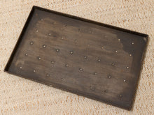 Load image into Gallery viewer, A rectangular dark brown board with a raised border and multiple evenly spaced small metal studs, photographed from above on a beige textured fabric background.