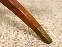 Load image into Gallery viewer, Close-up of a wooden furniture leg with a brass metal foot resting on a woven beige rug.