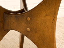 Load image into Gallery viewer, Close-up detail of a wooden chair leg with two round metal rivets and a warm brown wood finish against a light beige background.