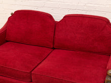 Load image into Gallery viewer, A close-up of a red upholstered loveseat or sofa section with two back cushions and two seat cushions, set against a white painted brick wall.