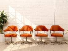 Load image into Gallery viewer, Set of four 1970s burnt orange velvet swivel chairs with curved backs and sculptural chrome loop bases