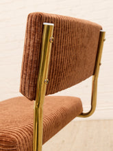 Load image into Gallery viewer, A close-up of a mid-century modern chair featuring a brown corduroy upholstered backrest and seat, supported by a polished gold metal frame.
