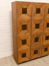 Load image into Gallery viewer, A mid-century modern wooden credenza or cabinet with a geometric, 3D pyramid pattern on the doors, set against a white brick wall and light beige carpet.
