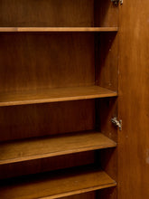 Load image into Gallery viewer, An empty wooden bookcase or cabinet with four shelves and a hinged door, shown in warm medium brown wood tones with metal hinges.