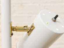 Load image into Gallery viewer, Close-up of a white adjustable lamp shade mounted on a white pole with a brass metal bracket and a black switch on top.