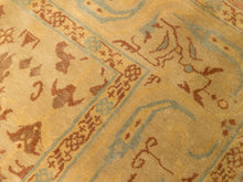 Load image into Gallery viewer, Close-up of a patterned area rug with a warm mustard yellow base, featuring traditional motifs in terracotta brown and light blue.