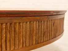 Load image into Gallery viewer, Close-up of a curved wooden table or cabinet with a slatted vertical wood panel side and a smooth dark wood top, shown against a light neutral background.