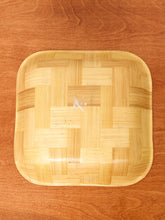 Load image into Gallery viewer, A square woven bamboo tray with rounded corners, displayed on a warm brown wooden surface.