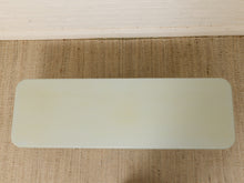Load image into Gallery viewer, A rectangular, frosted glass or acrylic table top with rounded corners, shown from a top-down view on a woven beige rug with a white baseboard above.