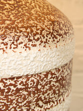 Load image into Gallery viewer, Close-up of a ceramic vessel with a textured, speckled brown and off-white glaze, showing a thick band of white around the middle.