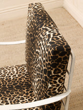 Load image into Gallery viewer, Close-up of a leopard-print upholstered chair cushion on a white metal chair, set on a beige carpeted floor.