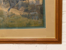 Load image into Gallery viewer, Close-up of a framed art print showing a horse scene, with a tan mat, dark green inner border, and a brown wood frame against a white brick wall.