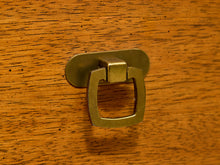 Load image into Gallery viewer, A close-up of a brass cabinet pull handle mounted on a warm wood-grained surface.