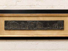 Load image into Gallery viewer, A rectangular black bas-relief wall plaque depicting a historical street scene with figures and buildings, mounted in a gold-toned frame against a white brick wall.