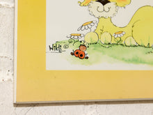 Load image into Gallery viewer, A close-up of a framed or matted art print showing a whimsical illustration of a yellow animal, daisies, green grass, and a ladybug. The print has a wide yellow border and the artist signature 'Hiklt' is visible.