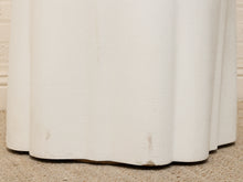Load image into Gallery viewer, Close-up of a white textured curtain or drape hanging down, showing the bottom hem resting on a beige carpet against a white wall.