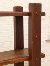 Load image into Gallery viewer, Close-up of a dark brown wooden shelf or table corner with visible metal hardware, set against a white painted brick wall.