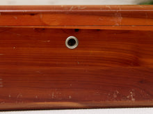 Load image into Gallery viewer, Close-up of a reddish-brown wooden box or drawer front with a small round metal lock or knob and visible wear marks on the surface.
