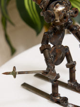 Load image into Gallery viewer, A handmade metal sculpture of a robot or mechanical figure made from screws, nuts, and bolts, holding a long screwdriver, standing on a white surface with a blurred indoor background.