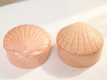 Load image into Gallery viewer, A pair of peach-colored shell-shaped keepsake boxes with ribbed textures, shown on a white textured fabric background.