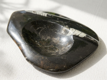 Load image into Gallery viewer, Vintage polished black fossil stone catchall with elongated white fossil inclusions and recessed center