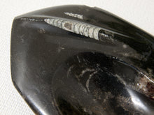 Load image into Gallery viewer, A close-up of a polished black stone or obsidian tool featuring a prominent textured band of gray and white inclusions, set against a neutral off-white textured background.
