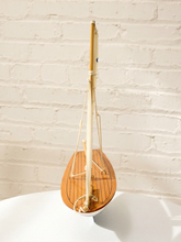 Load image into Gallery viewer, A miniature wooden model sailboat with a polished teak-style hull and light-colored mast, displayed on a white surface against a white brick wall background.