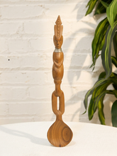 Load image into Gallery viewer, Vintage hand-carved wooden serving spoon with sculptural human figure, tall geometric headdress, and metal neck detail