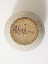 Load image into Gallery viewer, Top-down view of a handmade ceramic pot with a textured beige exterior and a natural brown glaze interior, featuring the cursive signature 'Adrian' on the base.