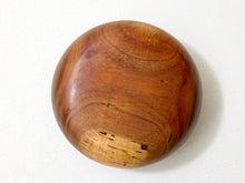 Load image into Gallery viewer, A round wooden bowl or dish with a smooth, polished finish, showcasing rich brown wood grain patterns, photographed on a white textured fabric background.