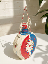 Load image into Gallery viewer, Vintage round leather-wrapped decanter with red blue and cream hand-stitched geometric decoration
