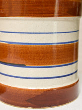 Load image into Gallery viewer, Close-up of a ceramic container with a glossy brown and cream horizontal striped pattern accented by thin blue lines.
