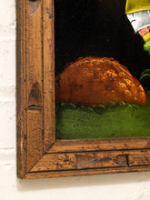 Load image into Gallery viewer, Close-up of a framed artwork showing a textured orange-brown dome or landscape shape above a green ground, set within a distressed wooden frame against a white wall.