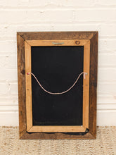Load image into Gallery viewer, A rustic framed chalkboard with a dark brown wooden frame, a black chalkboard center, and a pink string hanging across the middle, set against a white brick wall and woven rug.