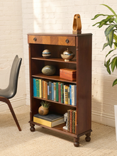 Load image into Gallery viewer, Antique tall wood bookshelf with four open shelves, upper drawer, round metal pulls, and turned front feet