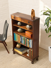 Load image into Gallery viewer, Antique tall wood bookshelf with four open shelves, upper drawer, round metal pulls, and turned front feet