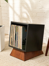 Load image into Gallery viewer, The Rizzo modern vinyl record holder with black angled storage case, warm wood-tone pedestal base, and records inside