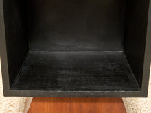 Load image into Gallery viewer, Close-up of the inside of a black wooden shelf or cubby box, showing the bottom shelf surface and dark wood grain, with a small portion of a brown wooden surface and light woven material visible around the edges.